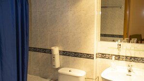 A bathroom with a toilet, bathtub, and sink. - HOTEL MAXIMUS (Las Navas del Marqués)