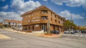 A hotel with a restaurant, a brick facade, and a clear blue sky. - HOTEL MAXIMUS (Las Navas del Marqués)