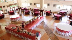 A spacious indoor dining area with multiple round tables and a central buffet table. - Wisma Makara Universitas Indonesia (Jakarta)