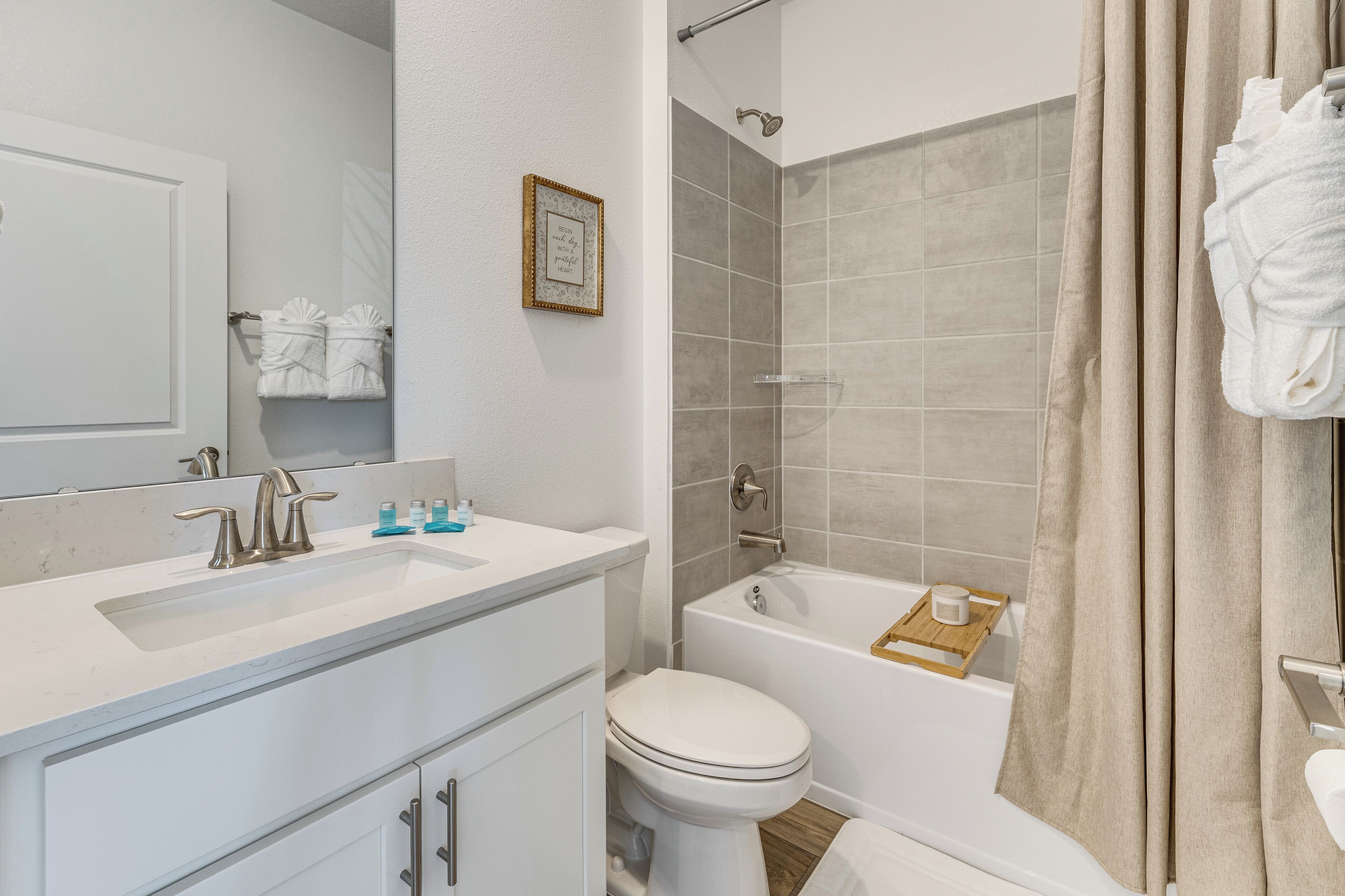 A bathroom with a sink, toilet, bathtub, and shower curtain.