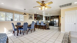 A spacious kitchen with a dining area, large windows, and a ceiling fan. - Wine Country Retreat in Galt w/ Vineyard Views (Galt)