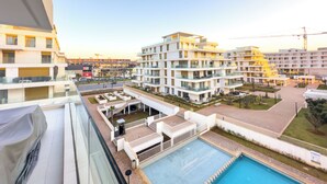 A modern apartment complex with multiple balconies, a swimming pool, and a view of the surrounding area. - The Carrousel Residence - Rabat (Rabat)