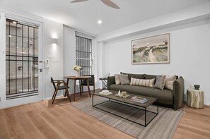 Un salon avec un canapé, une table basse et un tableau accroché au mur.