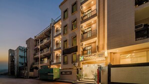 A multi-story building with a ground-level store named 'treebo,' balconies, and air conditioning units. - Treebo Premium Inn 62 (Noida)