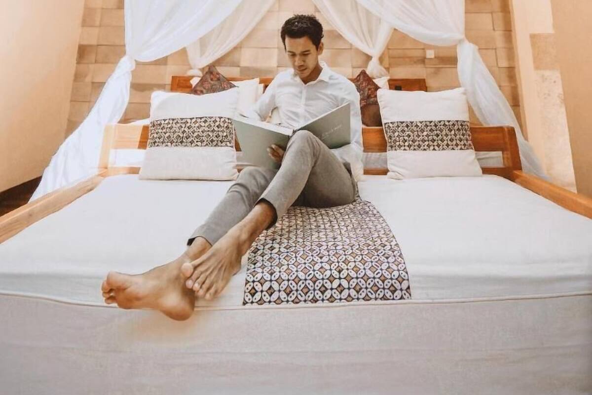 Une chambre avec un lit, un baldaquin et une lucarne circulaire.