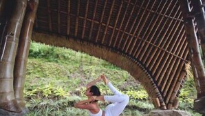 A person performing a yoga pose under a bamboo structure. - Munduk Moding Plantation (Gobleg)