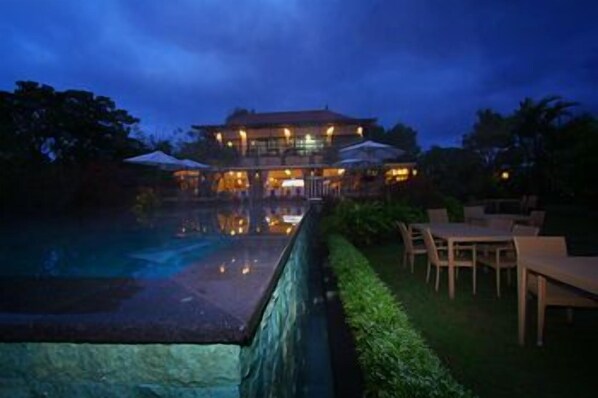 A large building with a swimming pool and outdoor seating.