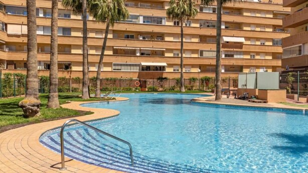 A swimming pool with a curved edge, surrounded by a brick walkway. - MAGNIFICENT PENTHOUSE OVERLOOKING THE POOL (Roquetas de Mar)