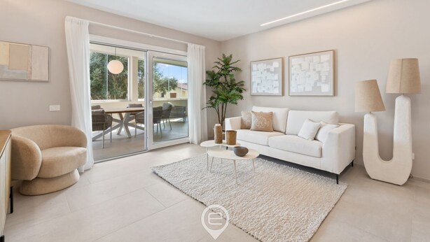 Un salon moderne avec un canapé blanc, une table basse et une grande fenêtre agrémentée de rideaux.