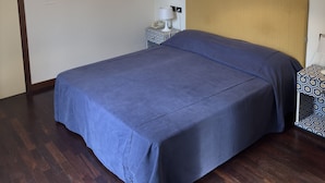 Une chambre à coucher avec un lit, une table de chevet avec une lampe et un luminaire suspendu.
