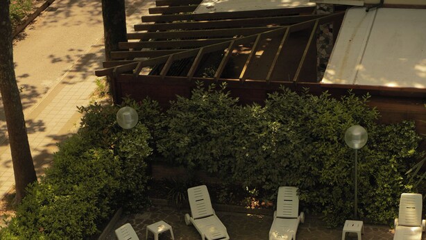 Une piscine avec des chaises longues et une pergola.