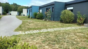 Une rangée de bâtiments modernes à un seul étage, avec un trottoir pavé devant.