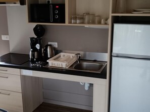 A kitchenette with a coffee maker, a kettle, a microwave, and a sink. - Cottage for 4 Guests With a Pool and Terrace (Malansac)