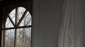 Et værelse med et stort vindue, en radiator og et gardin.