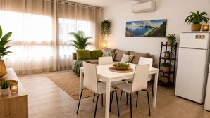 Uma sala de estar moderna com mesa de jantar, sofá e área de cozinha.