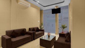 A modern hotel lobby with two sofas, a glass coffee table, and a flat-screen TV mounted on the wall. - Townhouse Ganesh Tekdi Temple Nagpur (Nagpur)