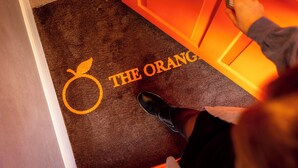 A carpet with a fruit logo and the text 'THE ORANGE' on a door. - 108 Shirland Road (London)