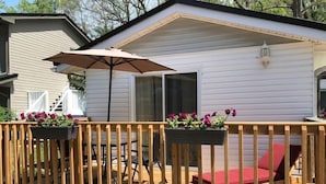 A mobile home with a wooden deck, outdoor furniture, and flower planters.