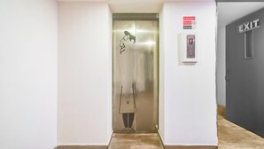 An elevator with a safety sign, an exit sign, and a fire alarm panel. - Deluxe Super Townhouse Lakdikapul (Hyderabad)