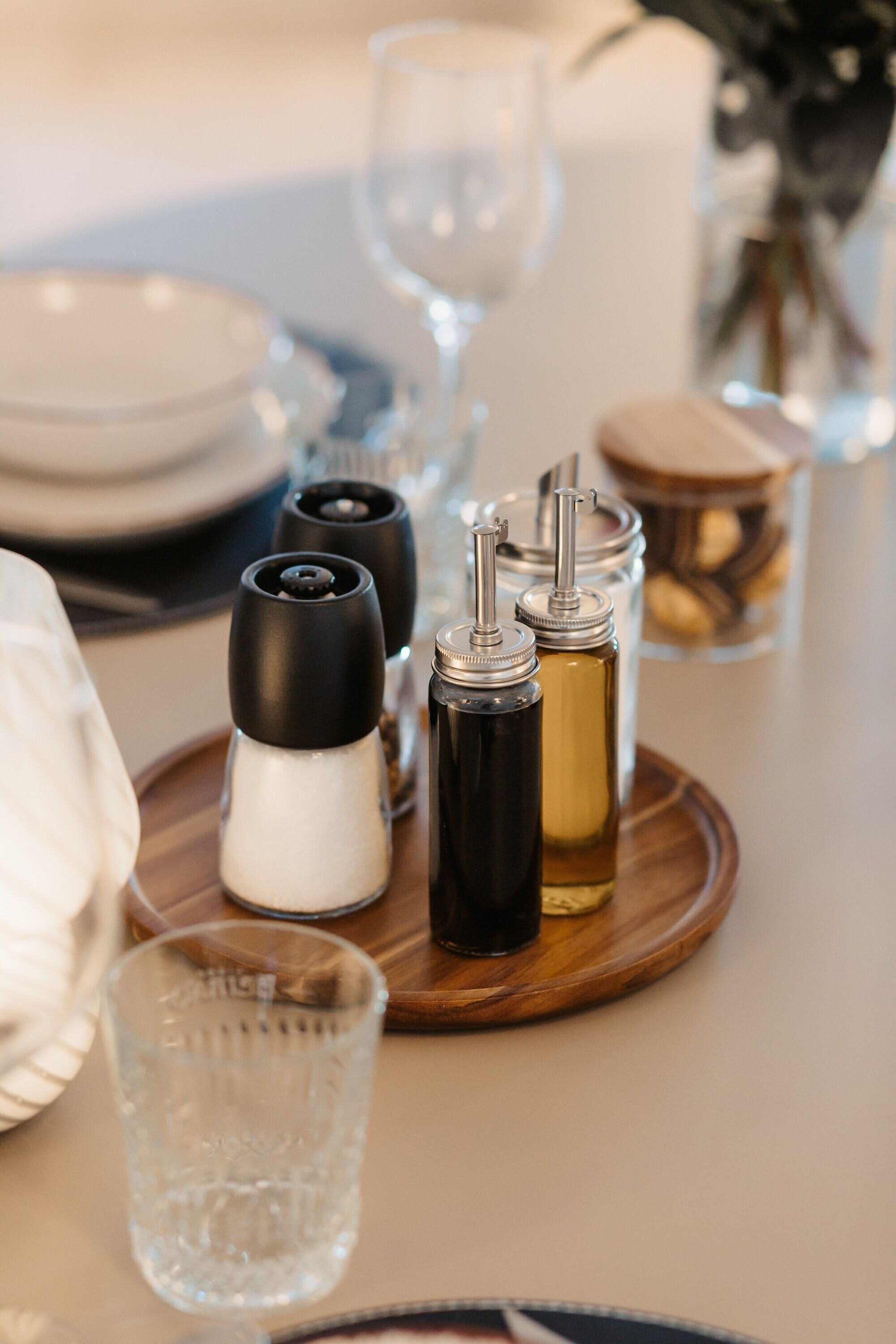 A dining table with salt and pepper shakers, a glass of water, and a candle holder.
