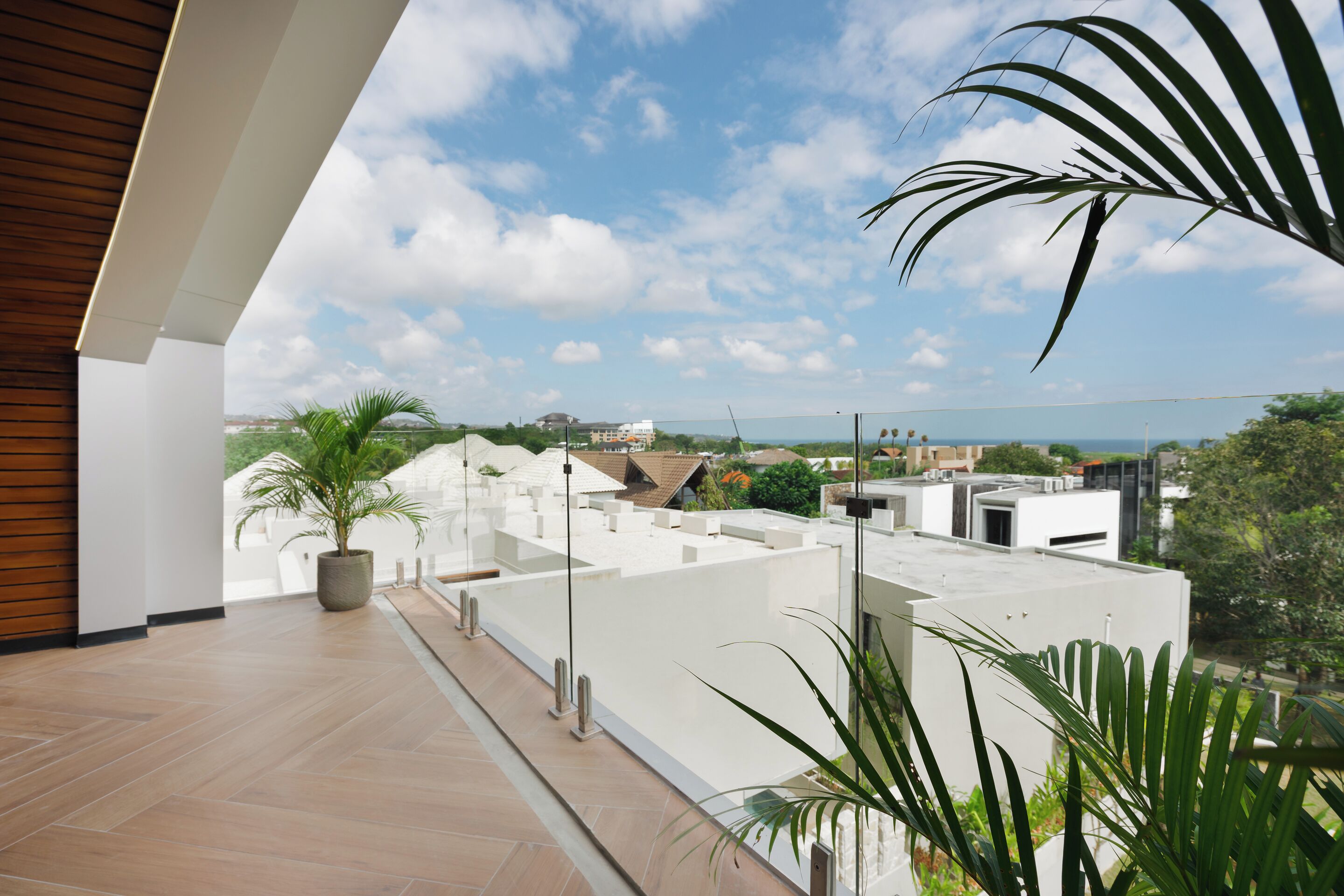 A modern building with a flat roof, potted plants, and a clear view of the surrounding area.