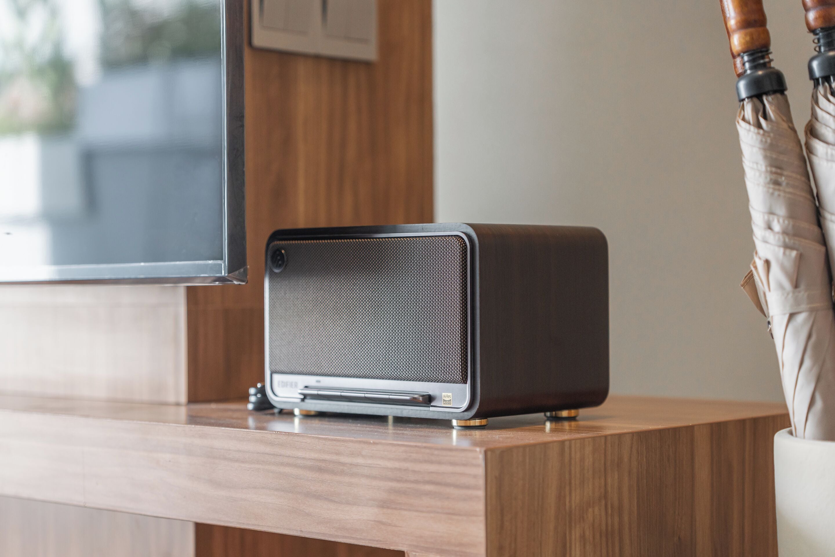 Une chambre moderne avec un bureau en bois, une radio ancienne et une fenêtre équipée de stores.