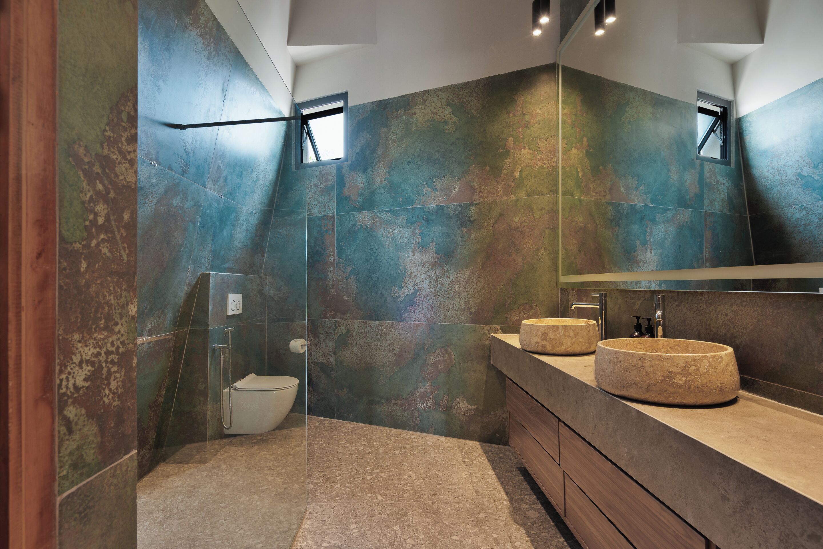 Une salle de bain moderne avec un grand miroir, deux lavabos et une douche.