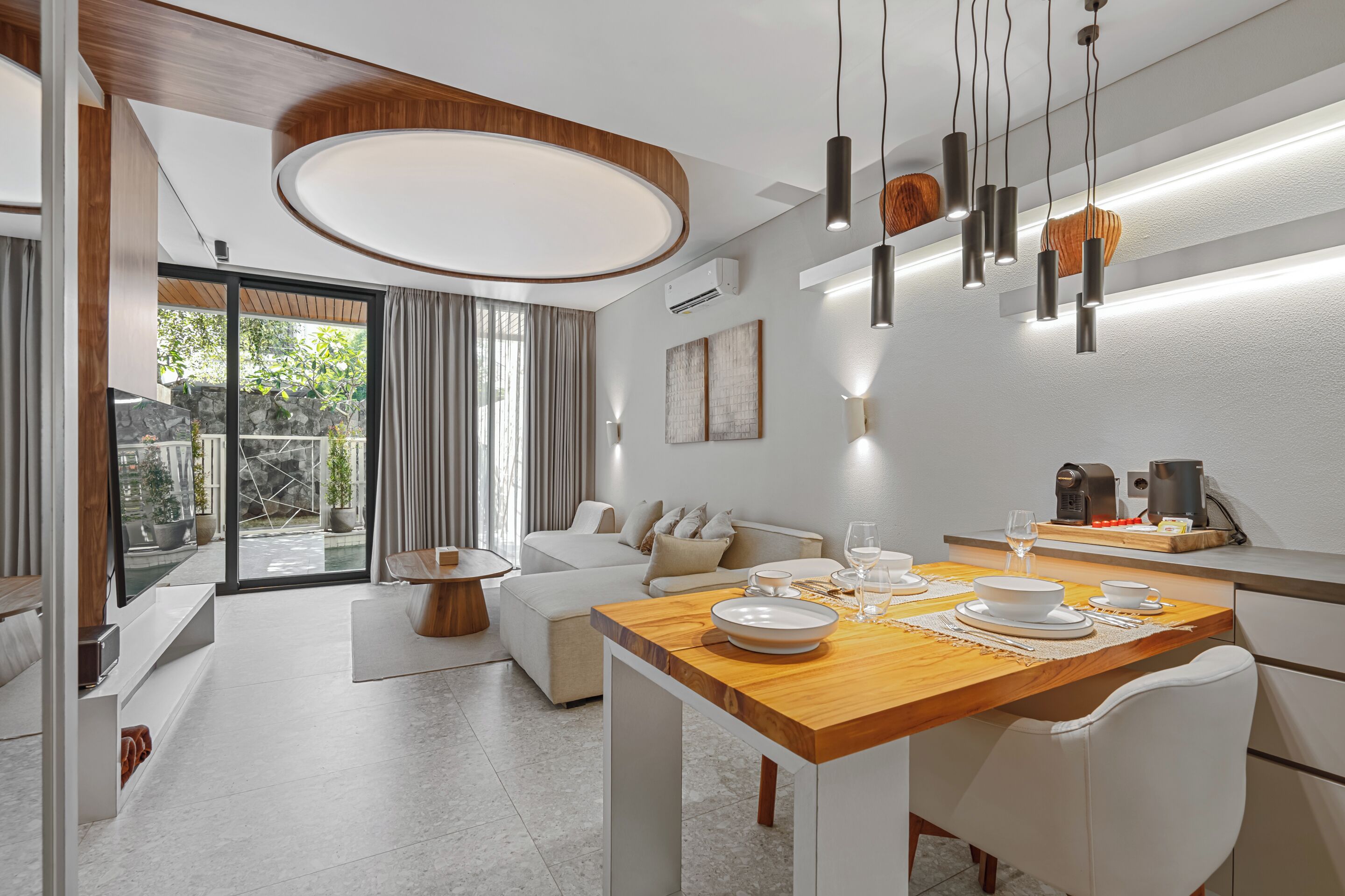 A modern kitchen with a wooden countertop, white appliances, and a dining area with a table set for four.