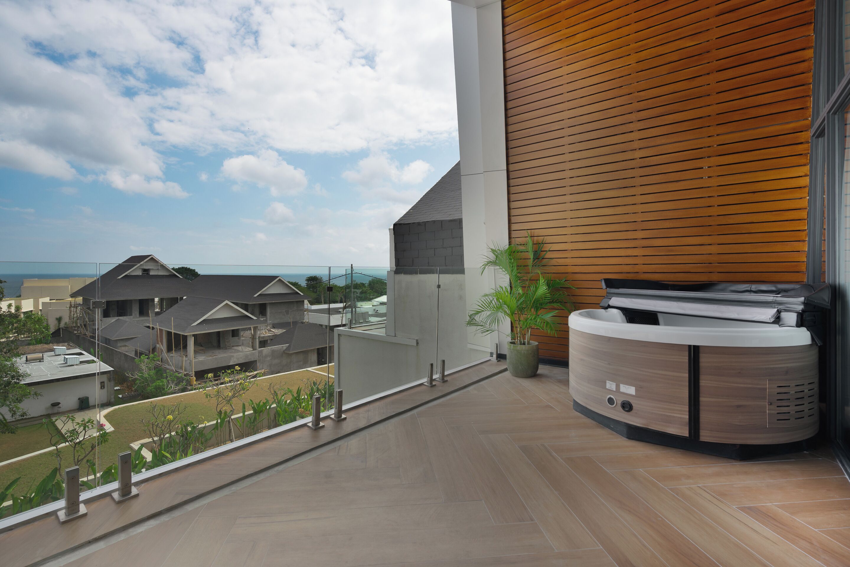 Un balcon donnant sur les maisons voisines et un mur en bois.
