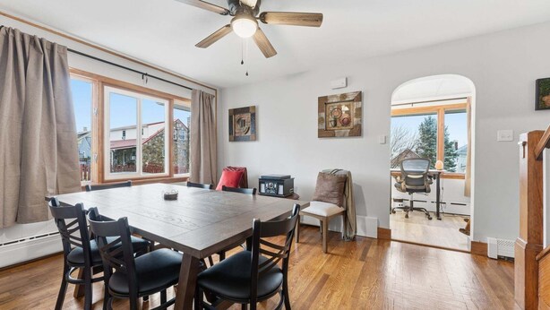 A dining area with a wooden table and chairs, a ceiling fan, and artwork on the walls. - Johnstown Stay Near Laurel Highlands & Hiking (Johnstown)