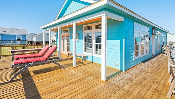 A beachfront house with a wooden deck, a covered porch, and a pool area. - Toes In The Sand 3 Bedroom Home (Port Bolivar)
