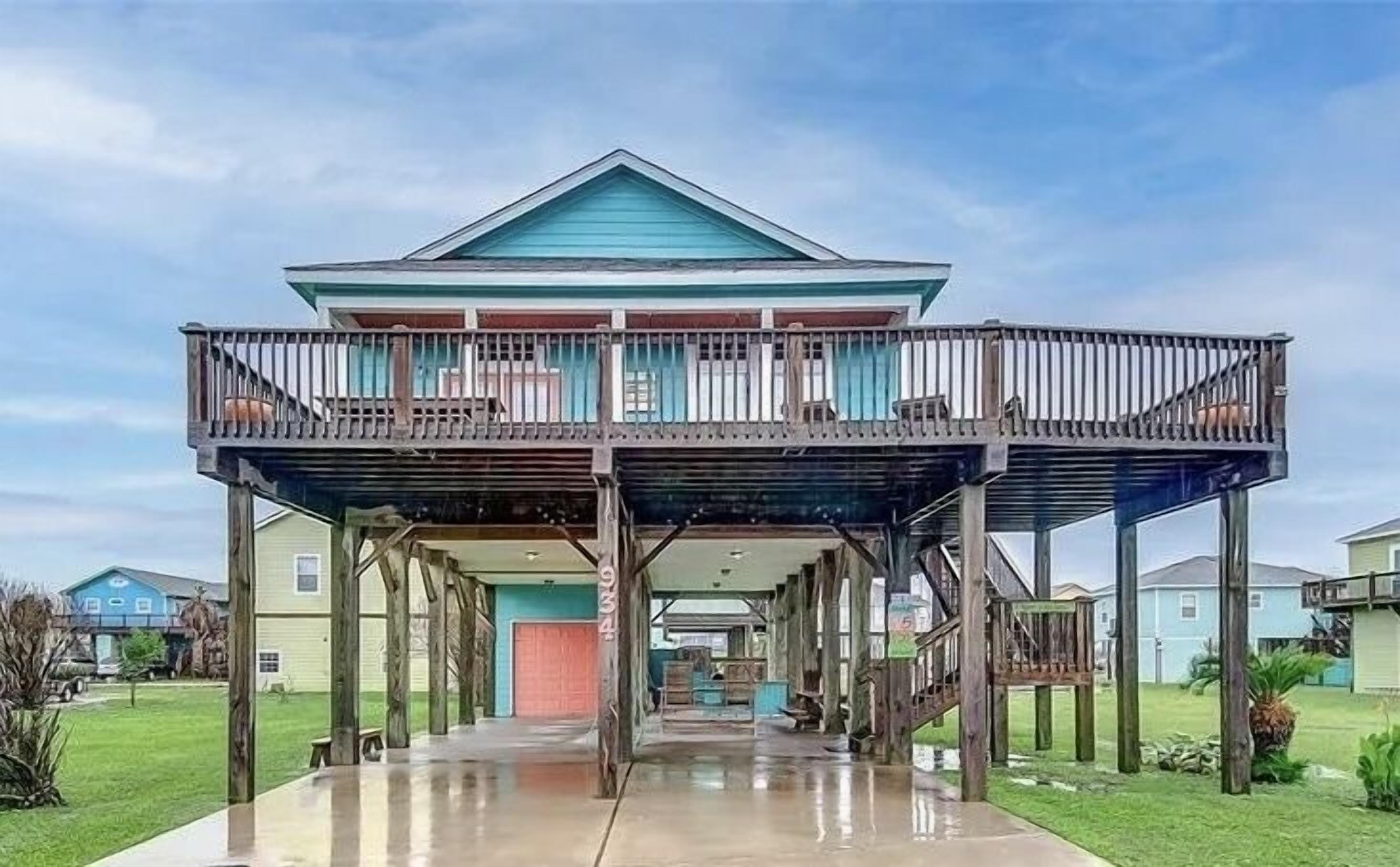 A two-story house with a covered porch and a red garage door.