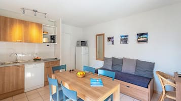 Een kleine keuken met een vaatwasser, magnetron en houten keukenkastjes.