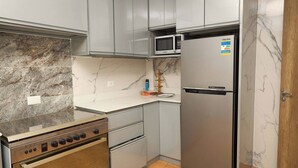 Una cocina equipada con estufa, horno, microondas y refrigerador.