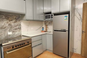 A kitchen with a stove, oven, microwave, and refrigerator. - Enjoyable 3-bedroom apartment with AC in vibrant Cairo (Cairo)