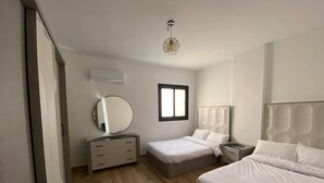 Un dormitorio con cama, cómoda, espejo, mesita de noche y ventana.