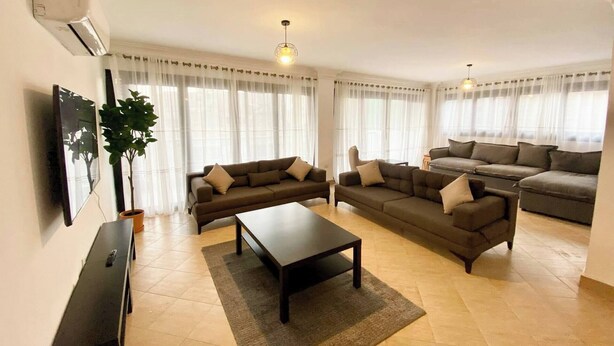 Una sala de estar con dos sofás, una mesa de centro y un televisor.