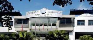 Un bâtiment sur lequel on peut lire l’inscription : « UNIVERSITÉ TERBUKA ».