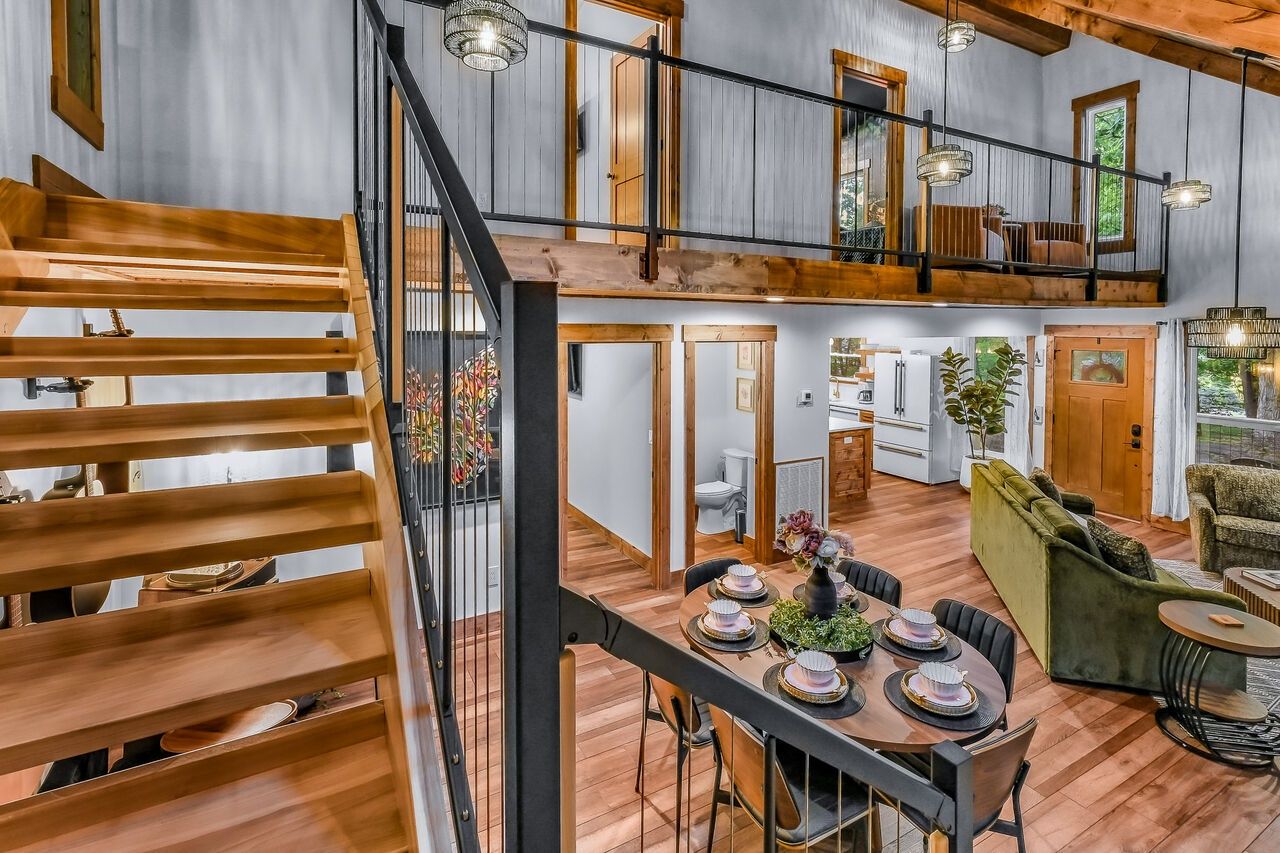Amplio interior estilo loft con comedor, escalera y sala de estar.