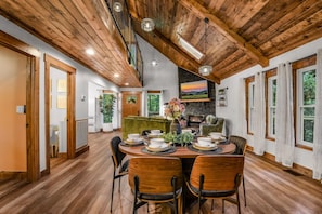 A dining area with a wooden ceiling, a fireplace, and a view of the outdoors. - Dolly's Harmony Haven 3 Bedroom Cabin (Pigeon Forge)