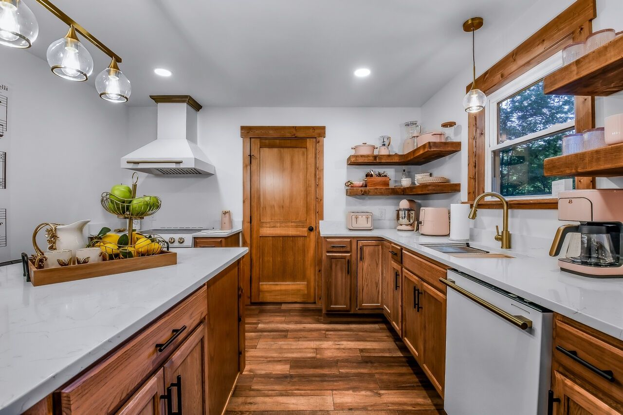 Una cocina moderna con armarios de madera, encimera blanca y una isla central.