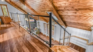 A wooden staircase with a metal railing leading to an upper floor. - Dolly's Harmony Haven 3 Bedroom Cabin (Sevierville)