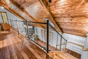 Eine Holztreppe mit Metallgeländer, die zu einer oberen Etage führt.