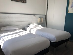 A room with two beds, a wooden headboard, a wall-mounted light, and a framed picture. - 55 M2 two-bedroom apartment in Villejuif, 6 minutes from the metro (Villejuif)