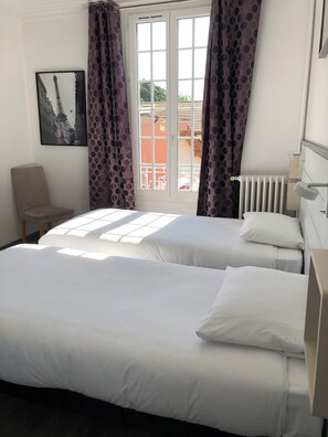 A bedroom with a bed, a chair, a radiator, and a window with curtains. - 55 m² two-room apartment in Villejuif, 6 minutes from the metro (Villejuif)