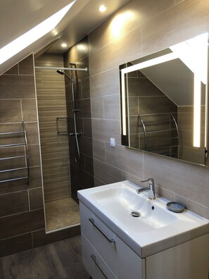 A modern bathroom with a shower, a sink, and a mirror. - 55 M2 two-bedroom apartment in Villejuif, 6 minutes from the metro (Villejuif)
