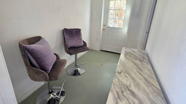 Une pièce avec deux chaises, une porte et un comptoir en marbre.