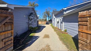 Un étroit chemin de gravier, bordé de deux mobil-homes et de clôtures en bois de chaque côté.