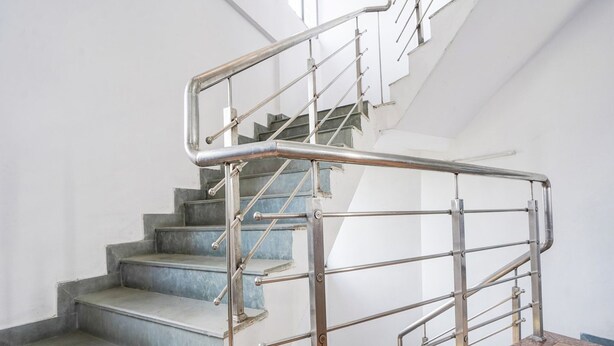 A staircase with metal railings and a wooden floor. - Hotel O Rajendra Nagar Hingna Road (Nagpur)