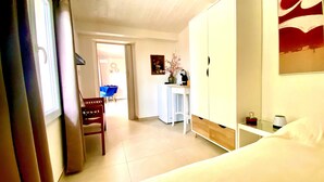 A hotel room with a bed, a desk, a chair, and a wardrobe.